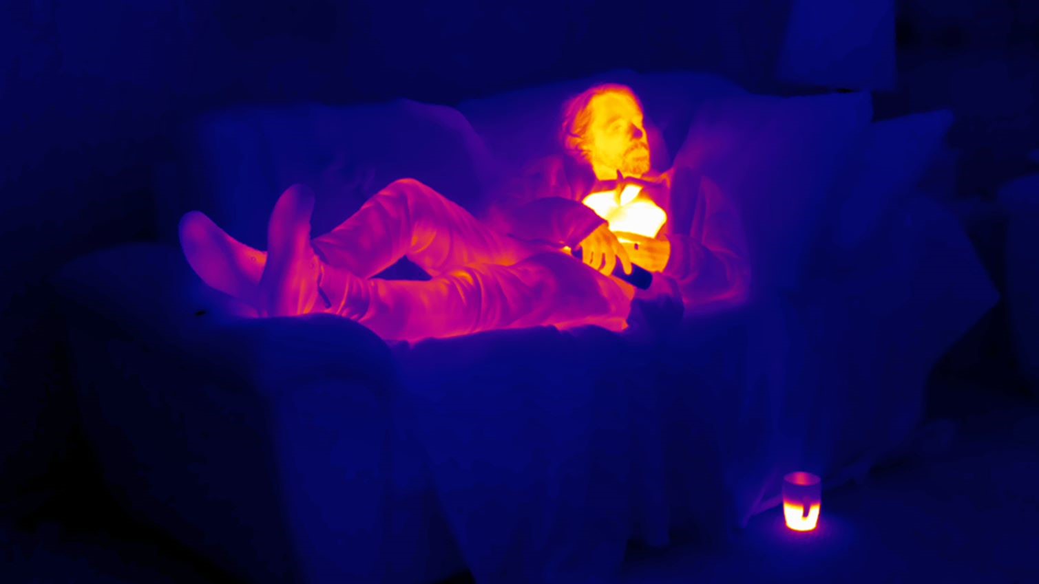 一个男人躺在沙发上的图像显示热的热图像