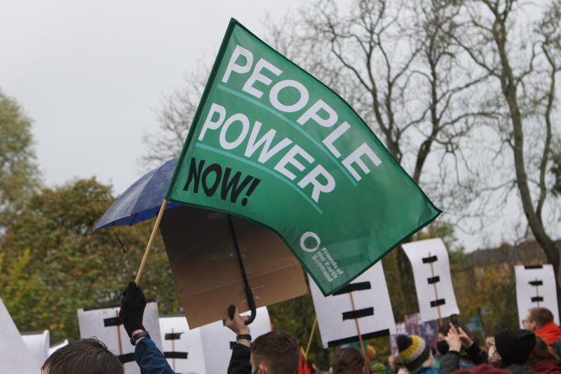 图像的抗议,放大的手一个标志,上面写着“人民力量现在
