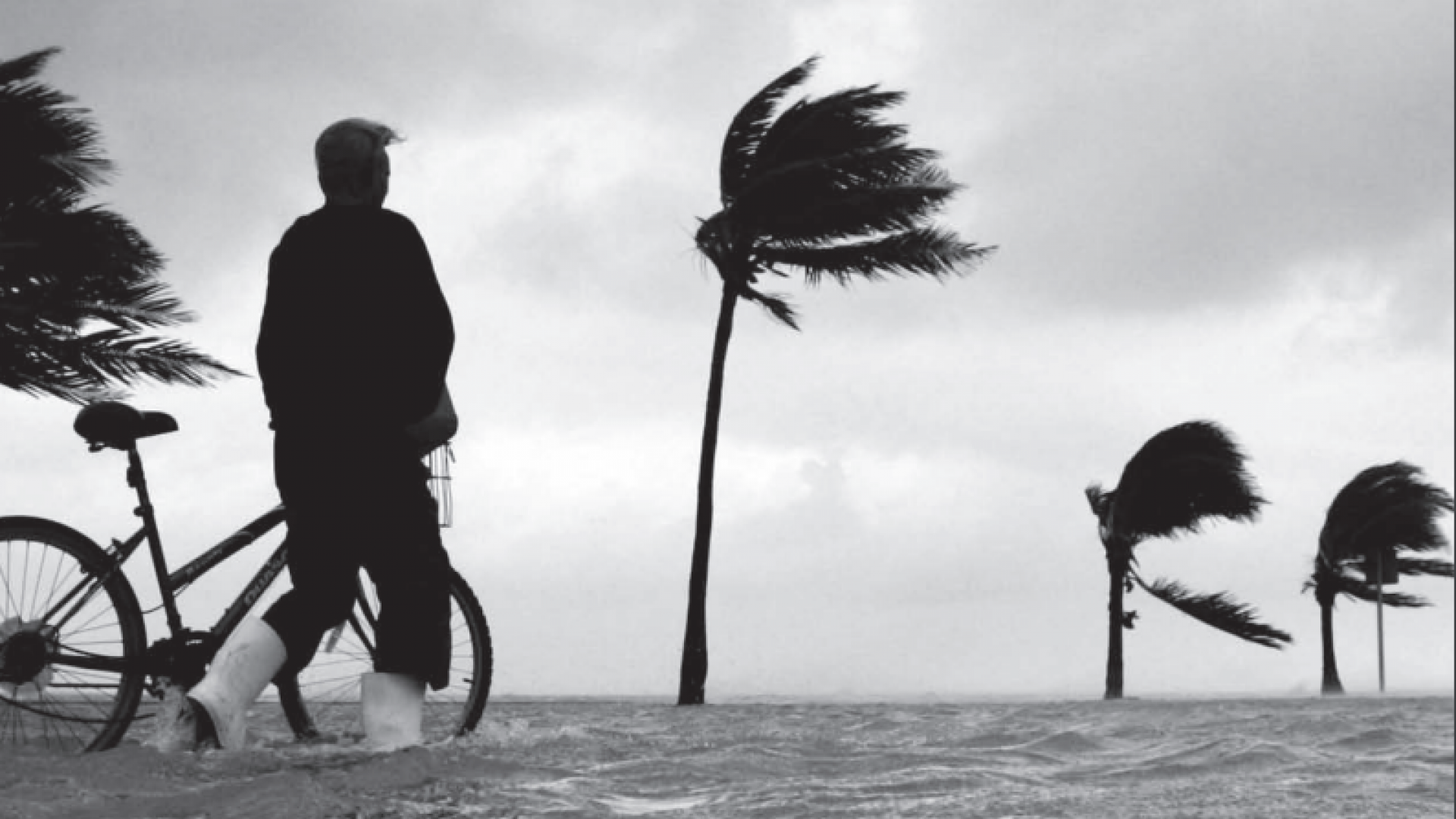 在热带山区，一个人骑着自行车穿过洪水